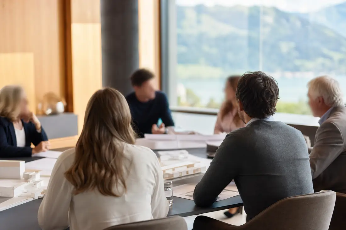 Mehrere Generationen einer Unternehmerfamilie im Gespräch in einem hellen Büro